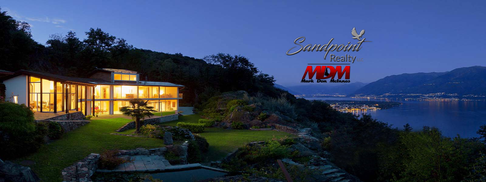 Evening waterfront home and mountain scenery with Sandpoint Realty and Mark Don McInnes branding
